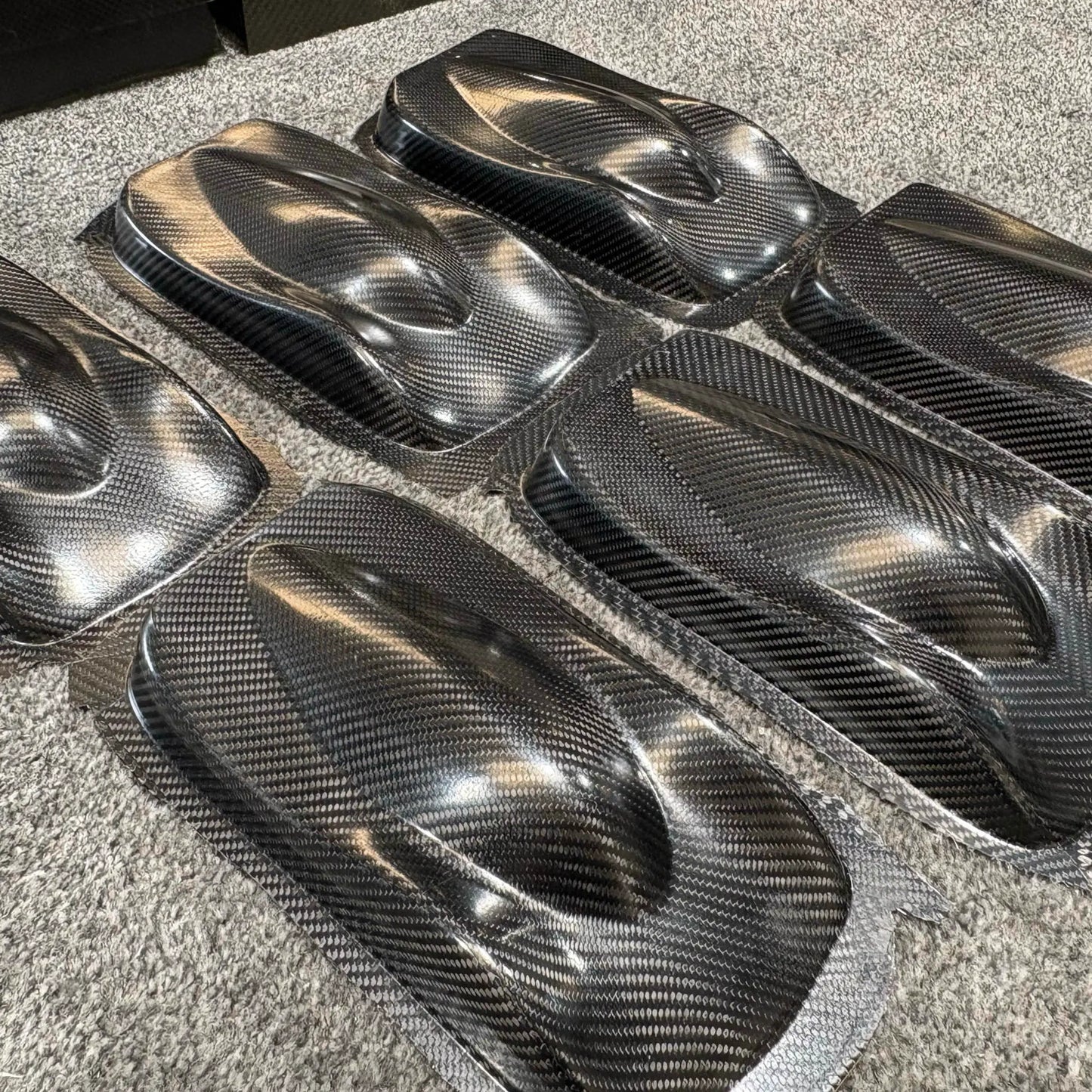 Finished carbon fibre components produced during a 2-day advanced composites training course, showing high-quality moulded parts.